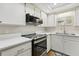 Well-lit kitchen with stainless steel microwave and stove, white cabinetry, and quartz countertops at 4510 Overlook Ne Dr # 224, St Petersburg, FL 33703