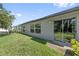The backyard features a well-maintained lawn, a window, and sliding glass doors to the house at 4726 Wild Senna Blvd, Tampa, FL 33619