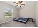 Cozy bedroom with carpet flooring, a ceiling fan, and a bright window allowing natural light at 4726 Wild Senna Blvd, Tampa, FL 33619