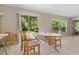 Cozy dining area with a white table, four chairs, and a sliding glass door to the outside at 4726 Wild Senna Blvd, Tampa, FL 33619