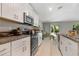 Well-lit kitchen with white cabinets, granite countertops, and stainless steel appliances at 4726 Wild Senna Blvd, Tampa, FL 33619