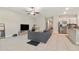 Open-concept living room with tile flooring, a ceiling fan, and a view into the kitchen at 4726 Wild Senna Blvd, Tampa, FL 33619