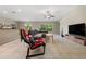 Spacious living room featuring tile flooring, a ceiling fan, and large windows offering bright natural light at 4726 Wild Senna Blvd, Tampa, FL 33619