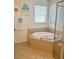 Bathroom with tiled floor and featuring a tub with tile surround and glass-enclosed shower at 4745 Trout River Xing, Ellenton, FL 34222