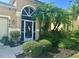 Inviting home entrance with lush landscaping, a custom front door, and ample curb appeal at 4745 Trout River Xing, Ellenton, FL 34222