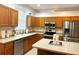 Traditional-style kitchen with light wood cabinets, tile backsplash, and stainless steel appliances at 4745 Trout River Xing, Ellenton, FL 34222