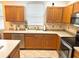 Functional kitchen with stainless steel dishwasher and oven and wooden cabinetry at 4745 Trout River Xing, Ellenton, FL 34222
