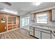 Eat-in kitchen boasts wood cabinets, a sink, and an adjacent breakfast nook with ample natural light at 4911 Bartelt Rd, Holiday, FL 34690
