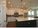 Bright kitchen with white cabinets, a large island, stainless steel appliances, and modern pendant lights at 5033 Chapel Row Ave, Apollo Beach, FL 33572