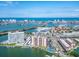 High-angle aerial showcases a complex with a pool, tennis court, and marina, against a backdrop of coastal waters and cityscape at 51 Island Way # 800, Clearwater Beach, FL 33767