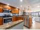 A kitchen featuring wooden cabinets, granite countertops, stainless steel appliances, and a bar-style counter at 51 Island Way # 800, Clearwater Beach, FL 33767