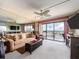 A bright living room with a ceiling fan, plush carpet, and sliding glass doors to the outside at 51 Island Way # 800, Clearwater Beach, FL 33767