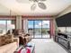 A sunlit living room with large sliding glass doors to balcony and comfy furniture at 51 Island Way # 800, Clearwater Beach, FL 33767