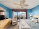A sunny main bedroom has a balcony, blue walls, and a cozy sitting area at 51 Island Way # 800, Clearwater Beach, FL 33767