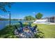 Outdoor fire pit and adirondack chairs in the backyard with a lake view at 5102 Pheasant Woods Dr, Lutz, FL 33558