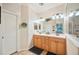 Bright bathroom featuring double vanities, decorative mirrors and neutral tile floors at 5102 Pheasant Woods Dr, Lutz, FL 33558
