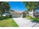 Suburban single-Gathering home featuring attached two-car garage, front yard landscaping, and neutral colors at 5102 Pheasant Woods Dr, Lutz, FL 33558