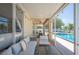 Enclosed patio featuring lake views, outdoor seating, string lights, a pool and a grill at 5102 Pheasant Woods Dr, Lutz, FL 33558