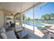 Enclosed patio featuring lake views, outdoor seating, string lights, a pool and a grill at 5102 Pheasant Woods Dr, Lutz, FL 33558