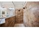 Walk-in shower features large beige tiling, with dual shower heads and glass partition at 5102 Pheasant Woods Dr, Lutz, FL 33558