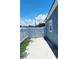 A concrete patio sits between the blue house and a white metal fence at 5106 Town N Country Blvd, Tampa, FL 33615