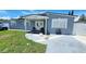 Charming gray home with a covered porch and double front doors at 5106 Town N Country Blvd, Tampa, FL 33615