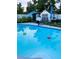 This in-ground pool is surrounded by lush greenery, pool floats, and an outbuilding for additional space at 5106 Town N Country Blvd, Tampa, FL 33615