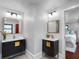 Modern bathroom with double vanities, dark wood cabinets and gold hardware, and tiled floors at 5518 21St S Ave, Gulfport, FL 33707