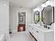 Bathroom featuring a double vanity with black fixtures, white cabinets and a walk-in shower at 5518 21St S Ave, Gulfport, FL 33707