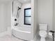 Modern bathroom featuring a bathtub with subway tile surround and black fixtures next to a window and toilet at 5518 21St S Ave, Gulfport, FL 33707