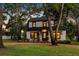 Two-story home featuring mature trees, lush lawn, and a charming, dark green front door at 5518 21St S Ave, Gulfport, FL 33707