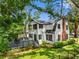 Exterior aerial view of a charming two-story home with lush landscaping, a large deck, and a well-manicured lawn at 5518 21St S Ave, Gulfport, FL 33707