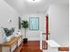 Hallway with hardwood floors, a wooden console table, and modern art decorating the walls at 5518 21St S Ave, Gulfport, FL 33707