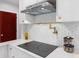 Modern kitchen featuring stainless steel hood, marble countertop, sleek cooktop, and stylish backsplash at 5518 21St S Ave, Gulfport, FL 33707