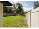 Spacious backyard is enclosed by a white privacy fence and mature landscaping at 5519 Kelly N Dr, St Petersburg, FL 33703