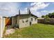 Back view of the home featuring a grassy yard and fence at 5519 Kelly N Dr, St Petersburg, FL 33703