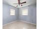 This bedroom features tile floors, a ceiling fan, and two windows for natural light at 5519 Kelly N Dr, St Petersburg, FL 33703