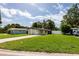 Charming single-story home featuring a well-maintained lawn and a long driveway leading to a covered carport at 5519 Kelly N Dr, St Petersburg, FL 33703