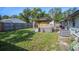 Fenced backyard featuring a hot tub under a gazebo and lush green grass at 5651 6Th St, Zephyrhills, FL 33542