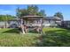 Backyard featuring a hot tub under a gazebo, chairs, and a well-maintained lawn at 5651 6Th St, Zephyrhills, FL 33542