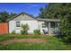 Charming single-story home with green lawn, mature trees, and welcoming front porch at 5651 6Th St, Zephyrhills, FL 33542