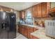 Kitchen featuring wood cabinets, modern appliances, and a sink with a view at 5651 6Th St, Zephyrhills, FL 33542