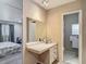 Bathroom features an ironing station, vanity with a mirror, and a toilet in separate room at 5806 Portsmouth Dr, Tampa, FL 33615