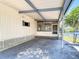 Covered carport area featuring concrete flooring and access to a screened-in porch overlooking the water at 5806 Portsmouth Dr, Tampa, FL 33615