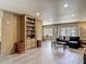 Open-concept living room featuring modern flooring, a bookcase, and ample natural light at 5806 Portsmouth Dr, Tampa, FL 33615