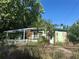 Charming home featuring a pergola covered front porch and stone accents, surrounded by lush greenery at 5853 39Th St N, St Petersburg, FL 33714
