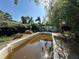 Backyard features an empty in-ground pool surrounded by mature trees at 5853 39Th St N, St Petersburg, FL 33714