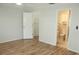 Bright bedroom featuring light hardwood floors, neutral walls, closet, and ensuite bathroom access at 6144 Elmhurst Dr, New Port Richey, FL 34653