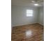 Well-lit bedroom featuring hardwood floors, neutral walls, and a window at 6144 Elmhurst Dr, New Port Richey, FL 34653