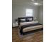Bedroom with modern decor, plush bedding, neutral tones, and hardwood floors at 6144 Elmhurst Dr, New Port Richey, FL 34653